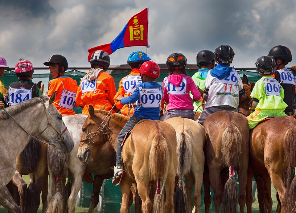 Mongolian children on their horses at the start line of a Naadam Festival horse race